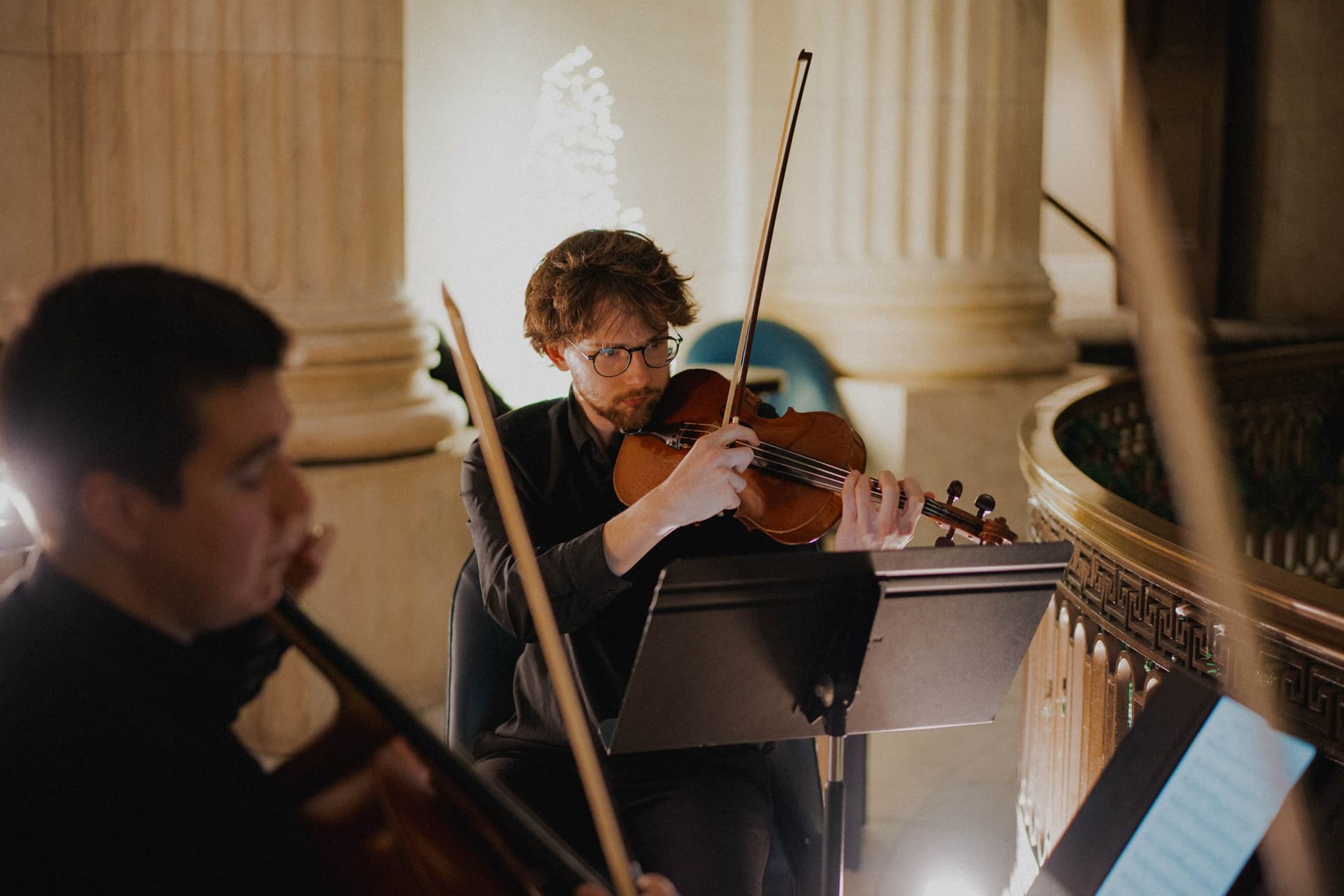 Violist performing among marble columns