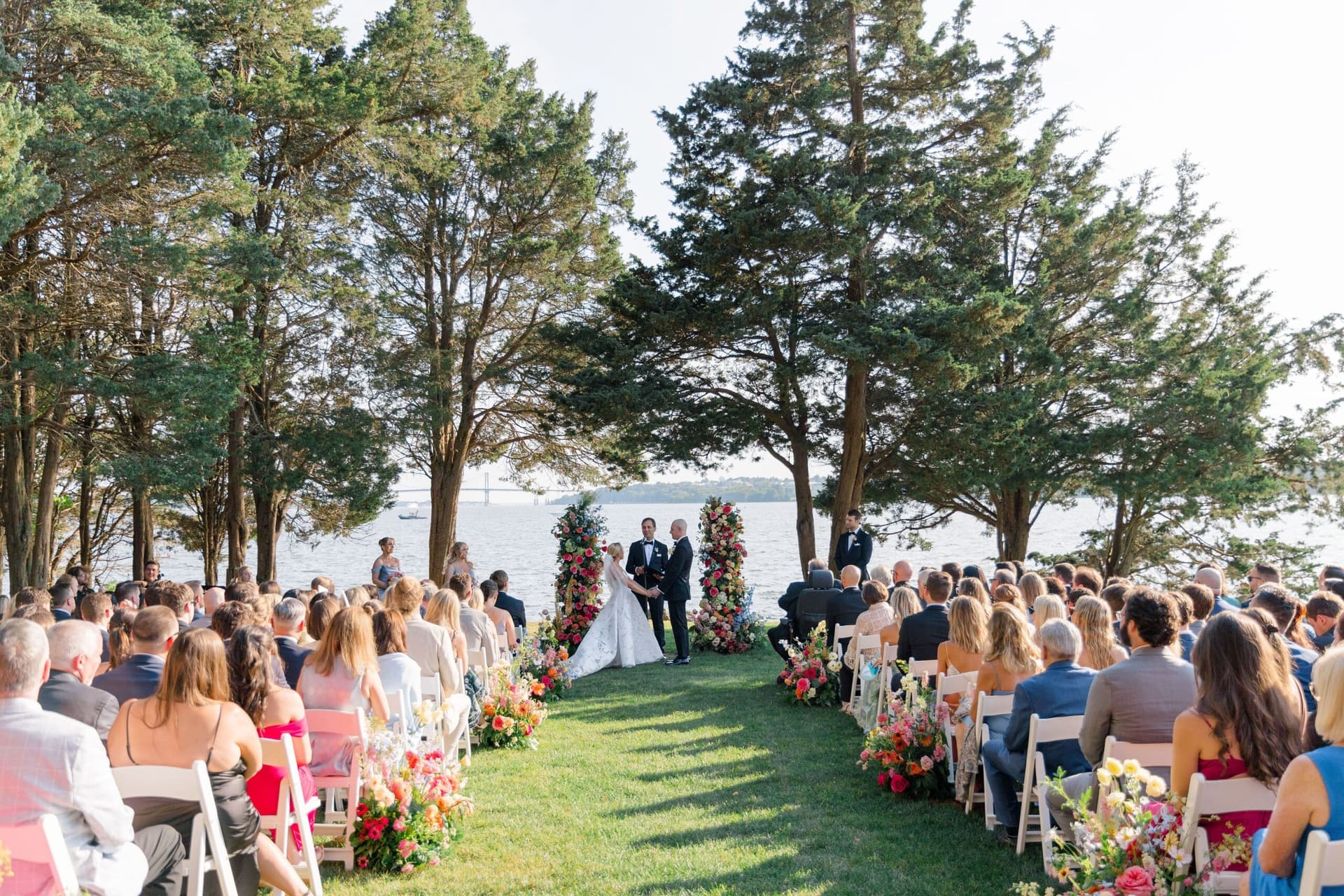 Waterfront wedding ceremony among cedar trees