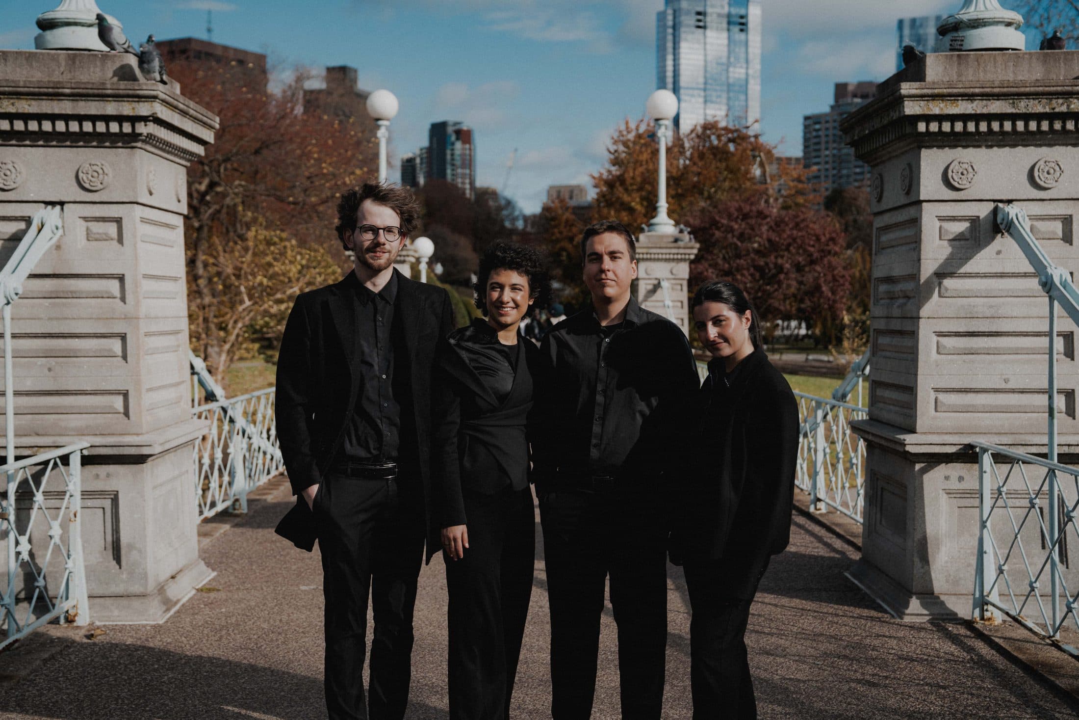 The quartet standing on a stone bridge in the Boston Public Garden